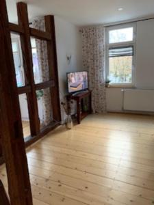 ein Wohnzimmer mit Holzboden und einem Fenster in der Unterkunft Appartment 5 in Braunlage