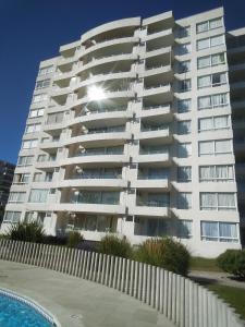 un gran edificio de apartamentos con piscina frente a él en La Serena hermosa, en La Serena