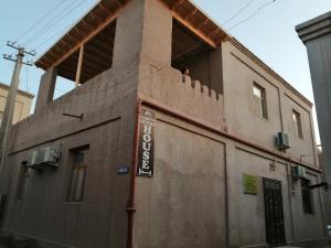 a building with a sign on the side of it at Naqqosh in Khiva