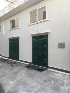 カゼルタにあるLa Corte del Re Borboneの白い建物の側面に緑の扉