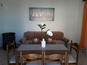 a dining room table with a vase of flowers on it at Delfin Apartments in Sveti Juraj