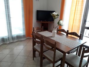 a dining room table with a vase of flowers on it at Delfin Apartments in Sveti Juraj