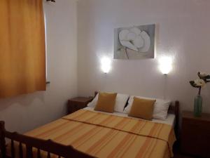 a small bedroom with a bed with two lamps at Delfin Apartments in Sveti Juraj