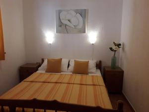 a bed in a room with two lights on at Delfin Apartments in Sveti Juraj