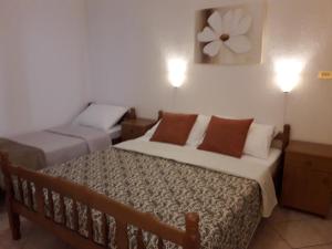 a bedroom with two beds and two lights on the wall at Delfin Apartments in Sveti Juraj