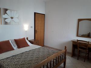 a bedroom with a bed and a desk and a mirror at Delfin Apartments in Sveti Juraj