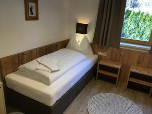 Dormitorio pequeño con cama con lámpara en Appartements Oberhof, en Flachau