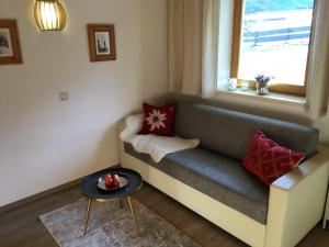 sala de estar con sofá y ventana en Appartements Oberhof, en Flachau