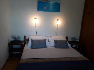a bedroom with a bed with two lights on the wall at Delfin Apartments in Sveti Juraj