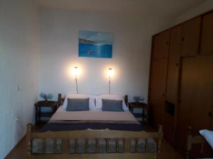 a bedroom with a bed with two lamps on the wall at Delfin Apartments in Sveti Juraj