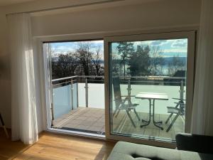 a sliding glass door with a table on a balcony at FeWo am Osthafen in Überlingen
