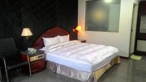 מיטה או מיטות בחדר ב-雲林東勢御花園汽車旅館