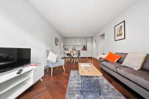 ein Wohnzimmer mit einem Sofa und einem Tisch in der Unterkunft 2 Bed Lux Apartments near Central London FREE WIFI by City Stay Aparts London in London