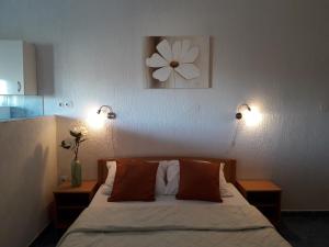 a bedroom with a bed with two lamps and a flower on the wall at Delfin Apartments in Sveti Juraj