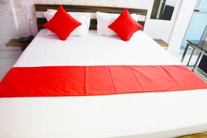 a bed with red and white pillows on it at Hotel Holydon in Siliguri