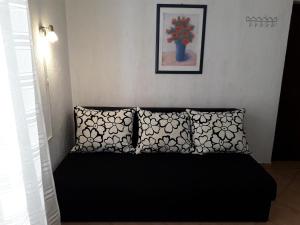 a bedroom with a black bed with two pillows at Delfin Apartments in Sveti Juraj