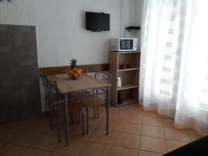 a dining room with a table and a microwave at Delfin Apartments in Sveti Juraj