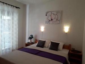 a bedroom with a bed with a flower painting on the wall at Delfin Apartments in Sveti Juraj