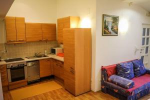 a kitchen with a couch and a kitchen with a stove at Apartman Rudi in Samobor