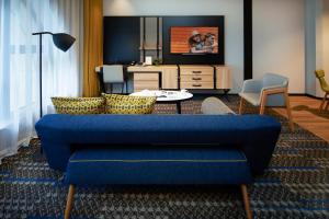 a living room with a blue couch and a tv at Citadines Namba Osaka in Osaka