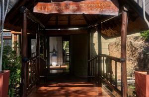uma entrada para um edifício com um sinal que diz bem-vindo ao alojamento de neta em Grand Kruger Lodge and Spa em Marloth Park