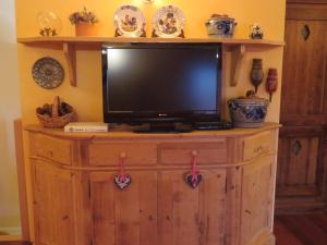 a tv on top of a wooden dresser at Isarco Suite in Vipiteno