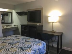 a hotel room with a bed and a desk and a television at Motel 6-Burnsville, MN in Burnsville