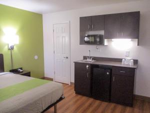 um quarto com uma cama e uma cozinha com paredes verdes em Motel 6-North Olmsted, OH - Cleveland em North Olmsted