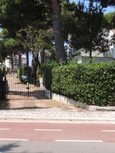 einen Zaun neben einer Straße mit Bäumen und einer Straße in der Unterkunft Villino Lory in Sperlonga
