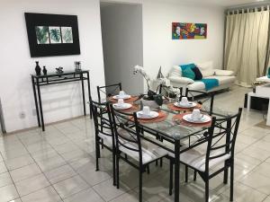 a living room with a table and chairs and a couch at Apt localização excelente in Maceió