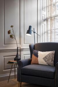 un soggiorno con divano blu e lampada di Superior Stays Rosewell House - Bath City Centre a Bath
