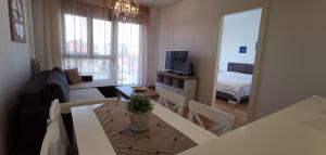 uma sala de estar com um sofá, uma mesa e uma televisão em NIKLUK em Belgrado