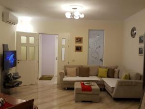 a living room with a couch and a tv at Holiday Center Apartment in Shkodër