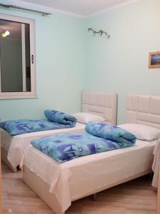 two beds sitting next to each other in a room at Holiday Center Apartment in Shkodër