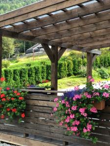a wooden pergola with flowers in a garden at SAGI 4 PRIVATE APARTMENT in Hafslo