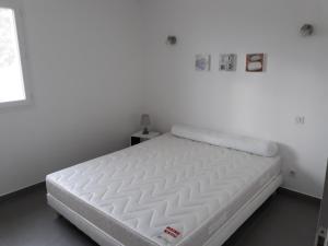 een wit bed in een witte kamer met een matras bij f3 vue mer et montagne in Ventiseri
