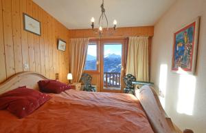 een slaapkamer met een bed en uitzicht op een berg bij Snowbird 214 in Bagnes