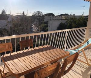 a wooden bench and a hammock on a balcony at Appartement avec terrasse à 100m de la plage in Saint-Cyr-sur-Mer