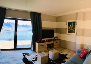 a living room with a television and a large window at Alice’s House in Fonteno