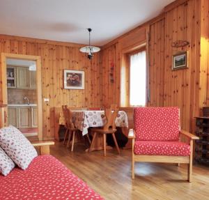 a living room with a table and chairs in it at Appartamenti De Betta in Sappada