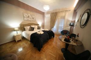ein Schlafzimmer mit einem großen Bett und einem Tisch in der Unterkunft Denise Luxury Apartment-Centre of Athens,Kolonaki in Athen