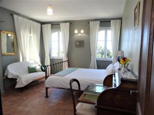 Château MontPlaisir charming b&b in Provence في فالريس: غرفة نوم بسرير واريكة ونوافذ