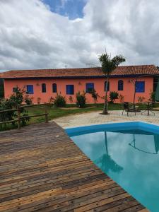 a house with a wooden deck and a building at Camping e Chalé Estação Rural in Bragança Paulista