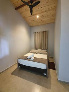 a bedroom with a bed with a ceiling fan at Camping e Chalé Estação Rural in Bragança Paulista