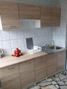 a kitchen counter with a sink and a basket of fruit at Wesoła Centrum in Suwałki
