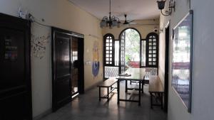a dining room with a table and chairs and windows at The Desire Hostel in New Delhi