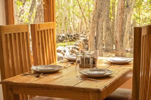 une table en bois avec des assiettes et des ustensiles dessus dans l'établissement Tushita Ladakh, à Leh