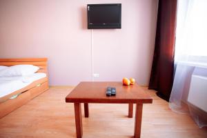 チュメニにある1к Светлая у Кристалла Зелинского 19のテーブル、ベッド、テレビが備わる客室です。