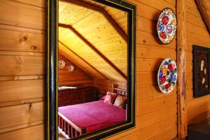 a mirror reflection of a room in a log cabin at Hotel Khatky Ruslany in Vorokhta