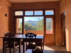 a dining room with a table and a large window at Queens Ark in Nallathanniya